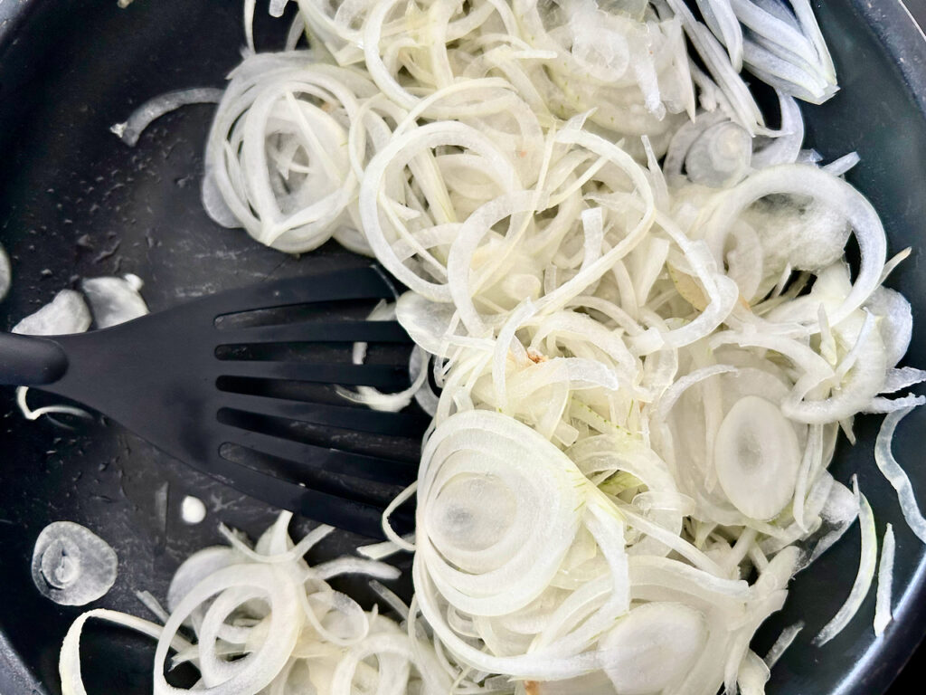 Zwiebeln mit etwas Butter in einer Pfanne dämpfen