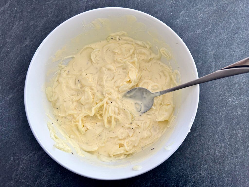 Zwiebeln mit der Schmandcreme mischen