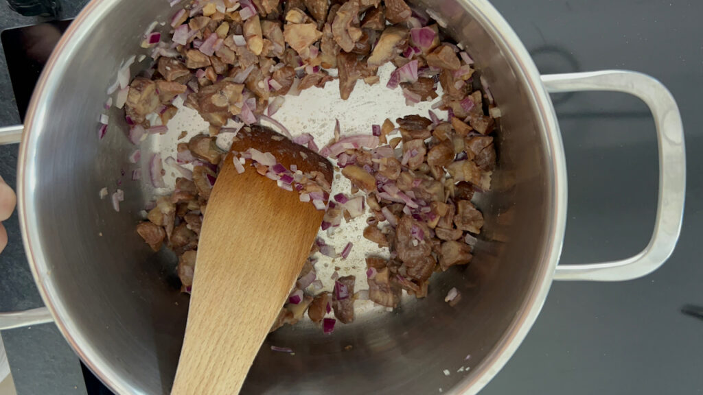 Zwiebeln, Knoblauch und Maronen in Butter anbraten