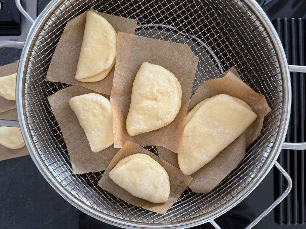 Die Baos mit Backpapier in den Dampfgaraufsatz legen