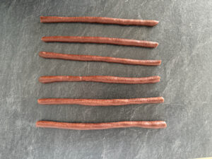 Den hellen Teig zu 6 Würstchen rollen