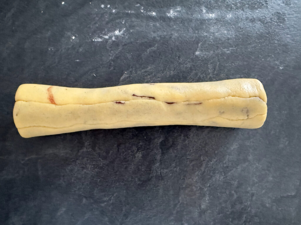 Die Würstchen aufeinander legen und zur Rolle formen