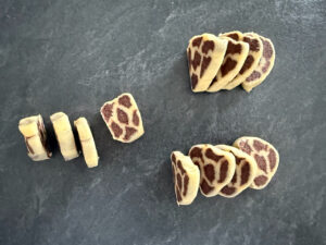 Plätzchen mit einem Messer von der Rolle schneiden