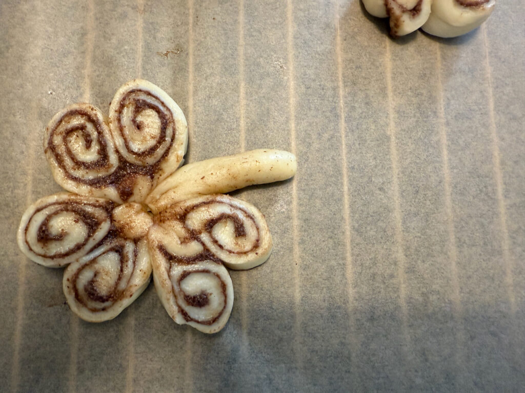 Aus dem restlichen Teig einen Stil formen und an das Kleeblatt anbringen